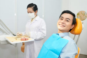 The patient waits patiently while the dentist prepares all the dental tools.